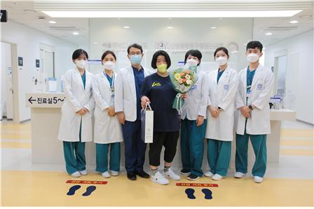 서울대치과병원 중앙장애인구강진료센터가 내원한 환자에게 꽃다발과 기념품을 전달하고 있다.