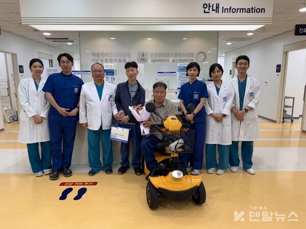 서울대학교치과병원 중앙장애인구강진료센터 의료진이 내원한 환자에게 꽃다발과 기념품을 전달하는 모습-덴탈뉴스-